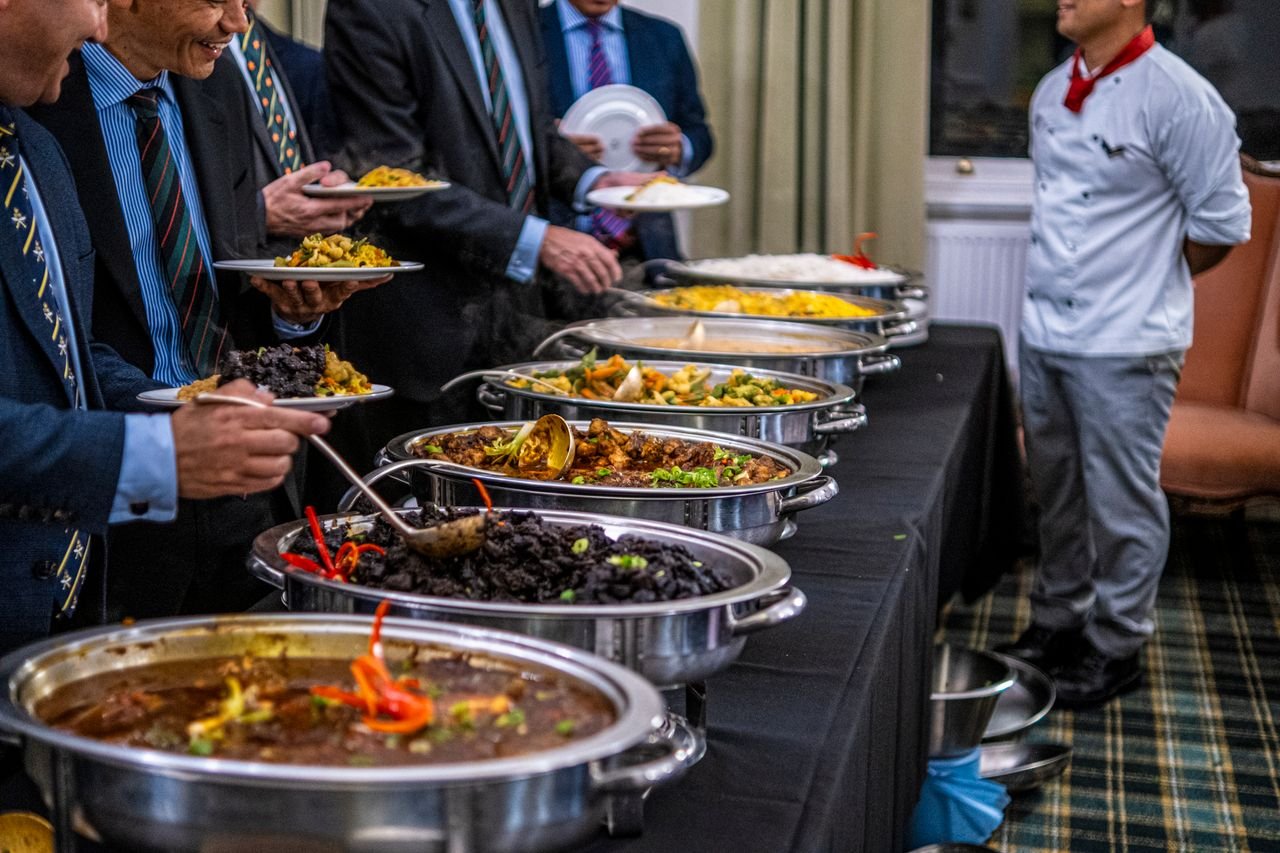 Cookie Policy Business professionals in suits enjoy a diverse buffet lunch selection at a formal event.