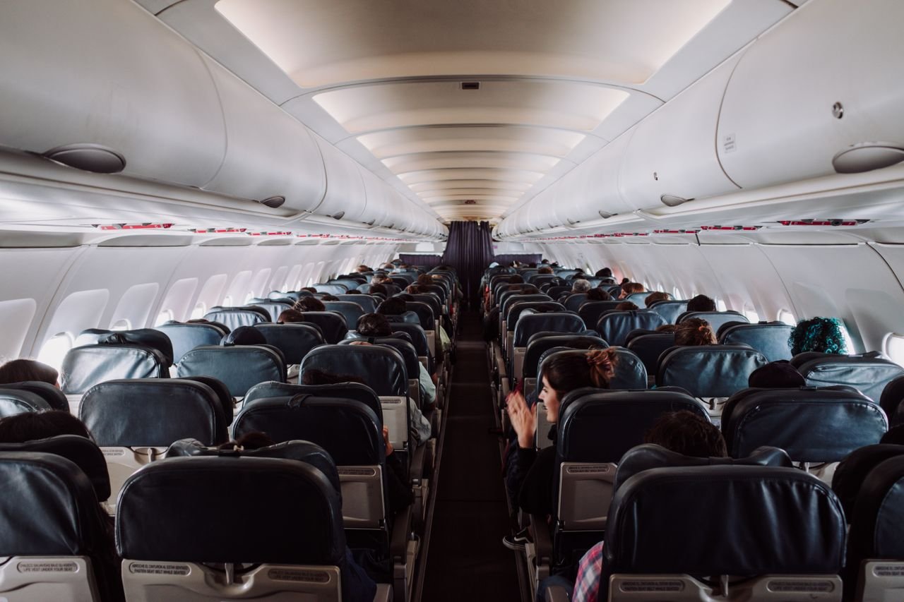 Cookie Policy A view of passengers seated inside a commercial airplane cabin during flight.