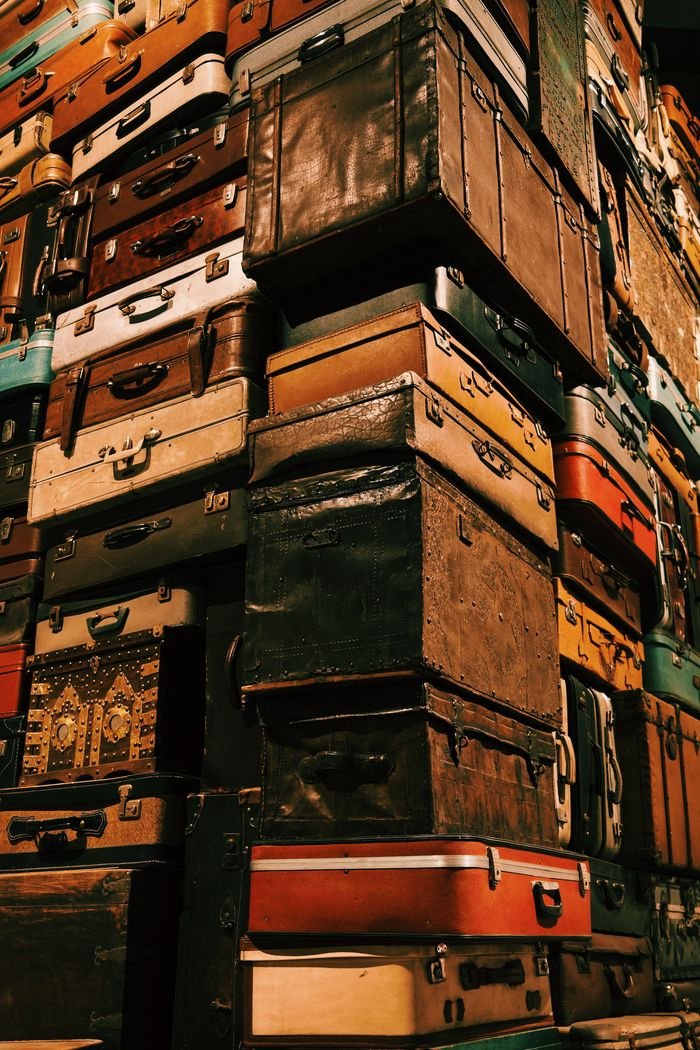 Home Towering pile of vintage suitcases representing travel and nostalgia.