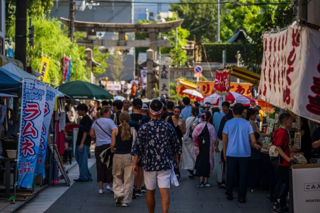 Lively scene of people exploring a Japanese street market during the summer.